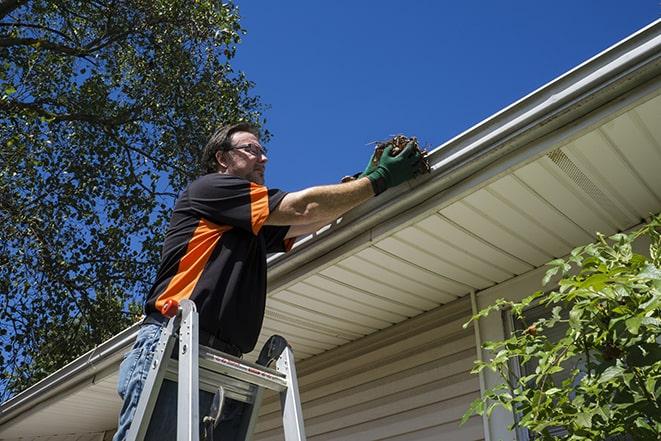 an experienced worker repairing a gutter on a house in Beacon, NY